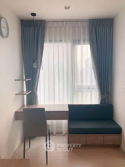 Modern study room with sleek desk, chair, and elegant curtains in a bright apartment.
