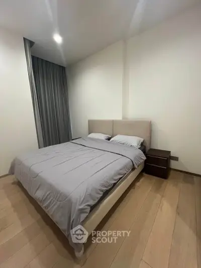 Modern bedroom with cozy bed and elegant wooden flooring
