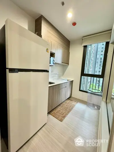 Modern kitchen with sleek design and large window offering natural light