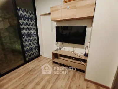 Modern living room with wooden flooring and mounted TV unit