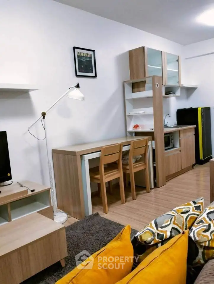Modern living room with compact kitchen and stylish decor in cozy apartment.