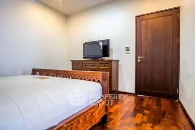 Cozy bedroom with wooden furniture and modern TV setup