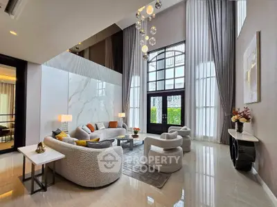 Luxurious high-ceiling living room with elegant decor and large windows