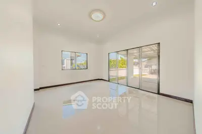 Spacious empty living room with large windows and glossy floors