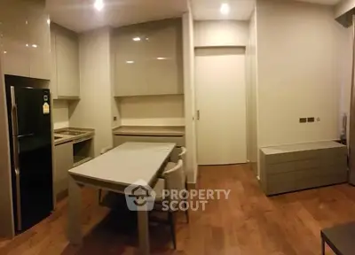 Modern kitchen with sleek cabinetry and dining area in a stylish apartment