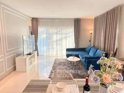 Elegant living room with blue sofa and large TV, perfect for relaxation.