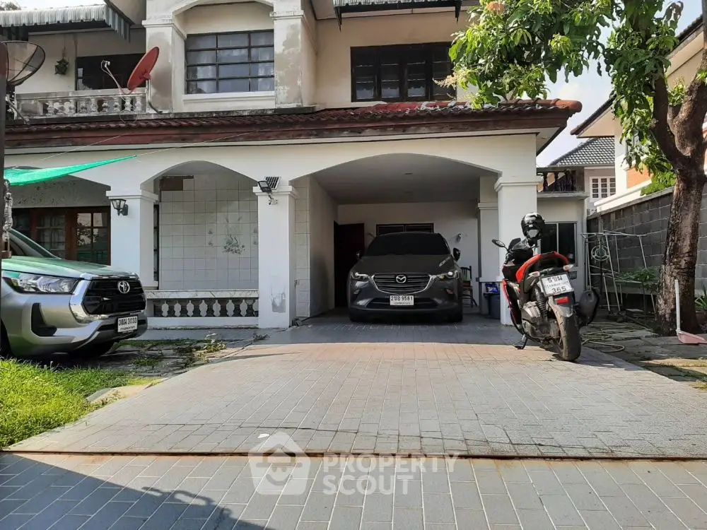 Charming suburban home with spacious driveway and garage, perfect for multiple vehicles.