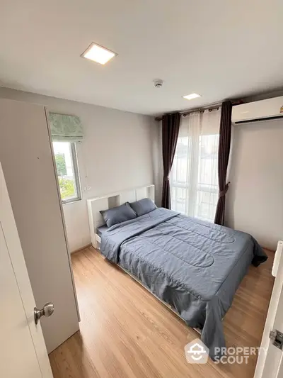 Modern bedroom with wooden flooring and natural light