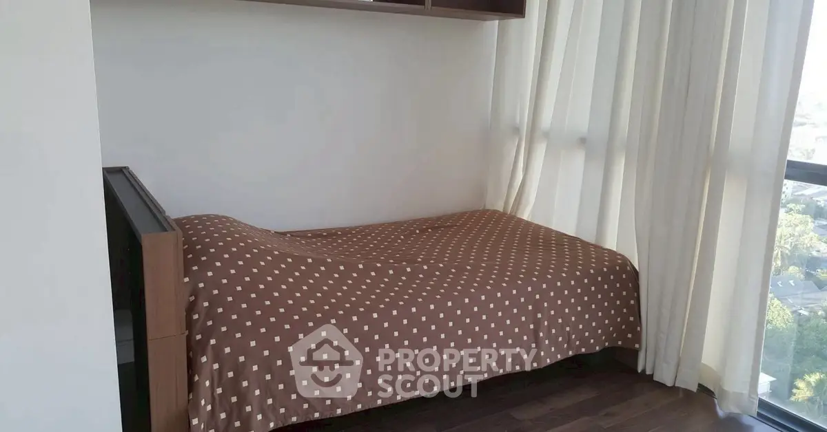 Cozy bedroom with large window and brown polka dot bedspread