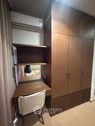 Modern study area with built-in wooden desk and wardrobe, featuring sleek design and efficient use of space.