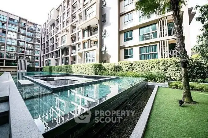 Modern apartment complex with luxurious pool and lush greenery