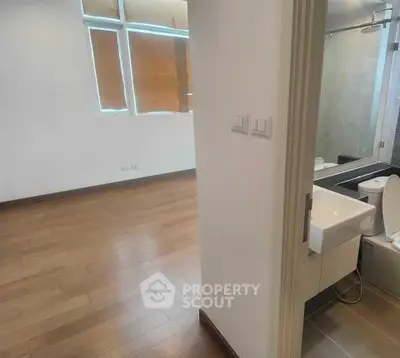 Modern apartment interior with wooden flooring and sleek bathroom design.