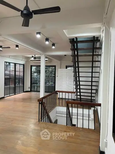 Spacious open-plan interior with modern staircase and large windows