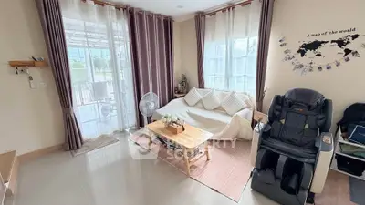 Spacious living room with modern decor and massage chair, perfect for relaxation.