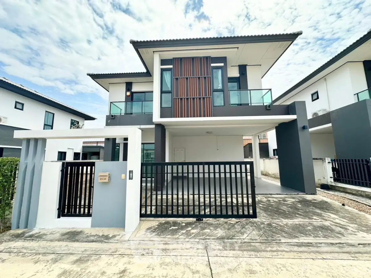 Modern two-story house with sleek design and spacious driveway in a suburban neighborhood.