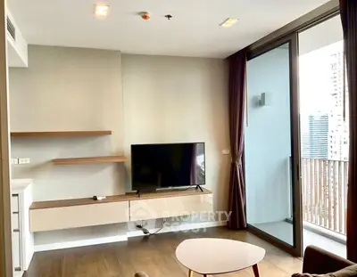 Modern living room with TV and balcony view in high-rise apartment