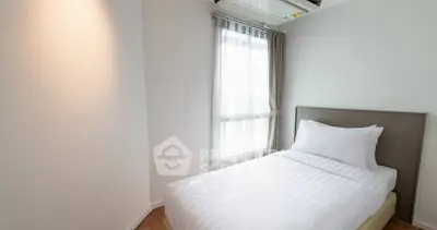 Cozy minimalist bedroom with natural light and modern air conditioning.