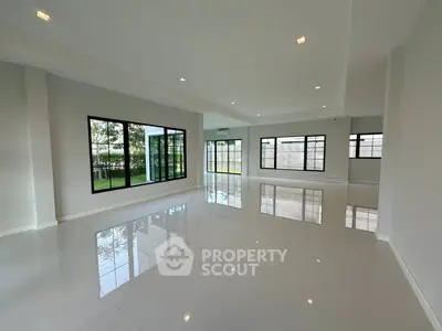 Spacious modern living room with large windows and glossy tile flooring