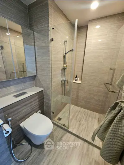 Modern bathroom with glass shower and sleek fixtures in contemporary design.