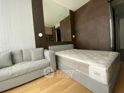 Modern bedroom with stylish geometric wall panels and cozy gray sofa
