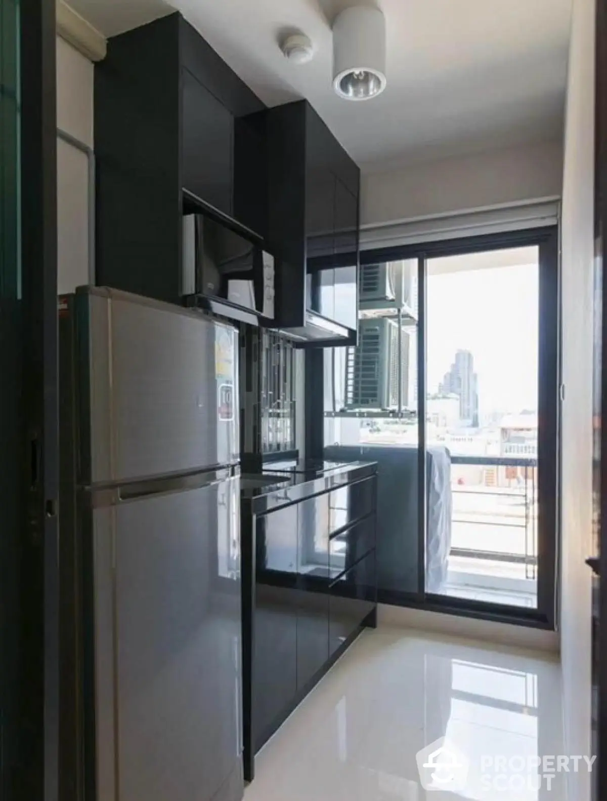 Modern kitchen with sleek black cabinets and city view from balcony