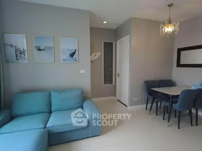 Modern living room with blue sofa and elegant dining area in stylish apartment.