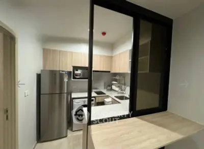 Modern kitchen with sleek appliances and closed layout in a stylish apartment.