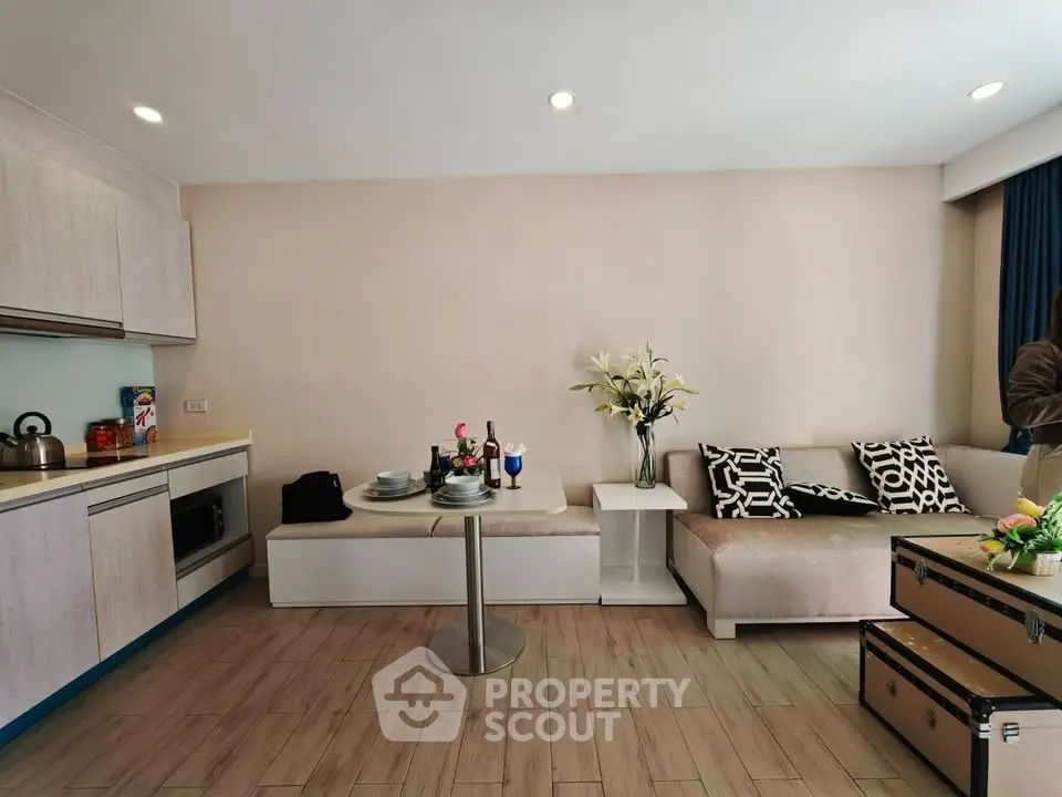 Modern living room with open kitchen, stylish decor, and cozy seating area in a contemporary apartment.