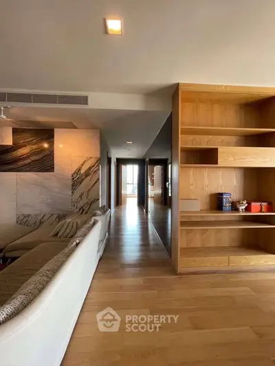 Spacious modern living room with elegant wooden shelves and stylish marble accents