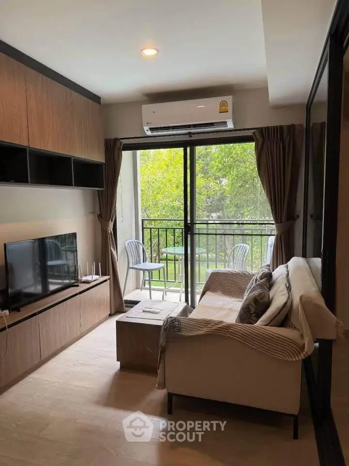 Cozy living room with balcony view, modern furnishings, and natural light in a stylish apartment.