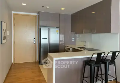 Modern kitchen with sleek cabinetry, stainless steel appliances, and breakfast bar seating.