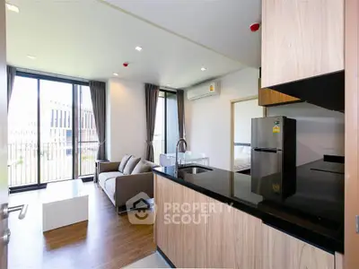 Modern open-layout kitchen and living room with sleek design and natural light.