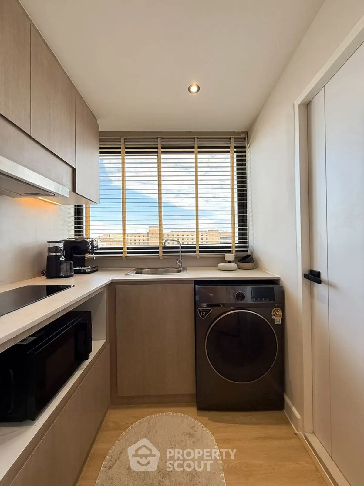 Modern kitchen with washing machine and city view from window