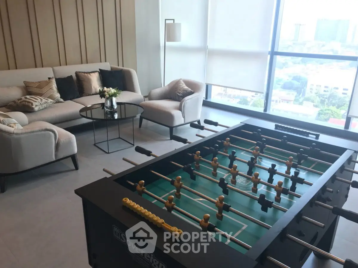 Stylish living room with foosball table and city view, perfect for entertainment and relaxation.