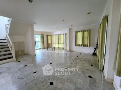 Spacious living room with marble flooring and large windows in a modern home
