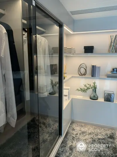 Luxurious modern walk-in closet with sleek glass doors and elegant shelving