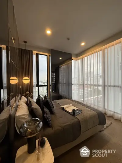 Luxurious bedroom with floor-to-ceiling windows and modern decor in high-rise apartment