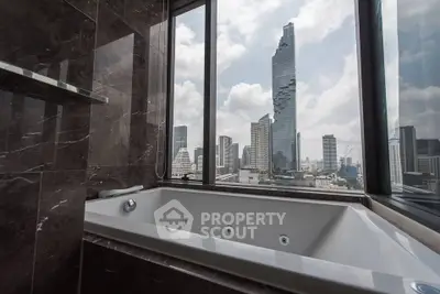 Luxurious bathroom with stunning city skyline view from large windows.