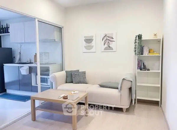 Chic living room with cozy sofa and modern kitchen in open layout apartment.