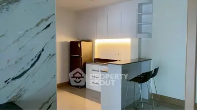 Modern kitchen with sleek cabinetry and breakfast bar in a stylish apartment.