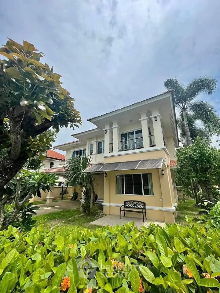 Charming two-story house with lush garden and elegant balcony in serene neighborhood.