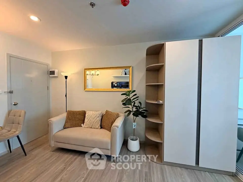 Modern living room with stylish sofa, elegant decor, and sleek storage unit in a cozy apartment.