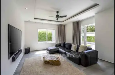 Spacious modern living room with large leather sofa and sleek decor.