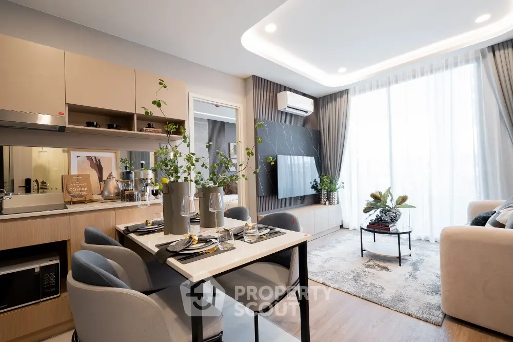 Modern living room with open kitchen, stylish decor, and natural light.