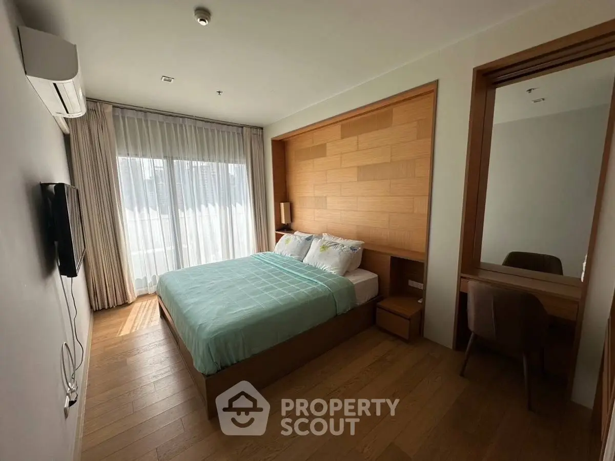 Modern bedroom with wooden accents and natural light in luxury apartment