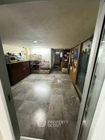 Spacious basement storage area with tiled flooring and ample shelving.