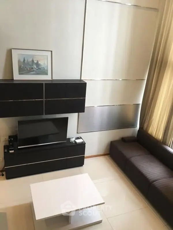 Modern living room with sleek furniture and high ceilings, featuring a stylish entertainment center and elegant decor.