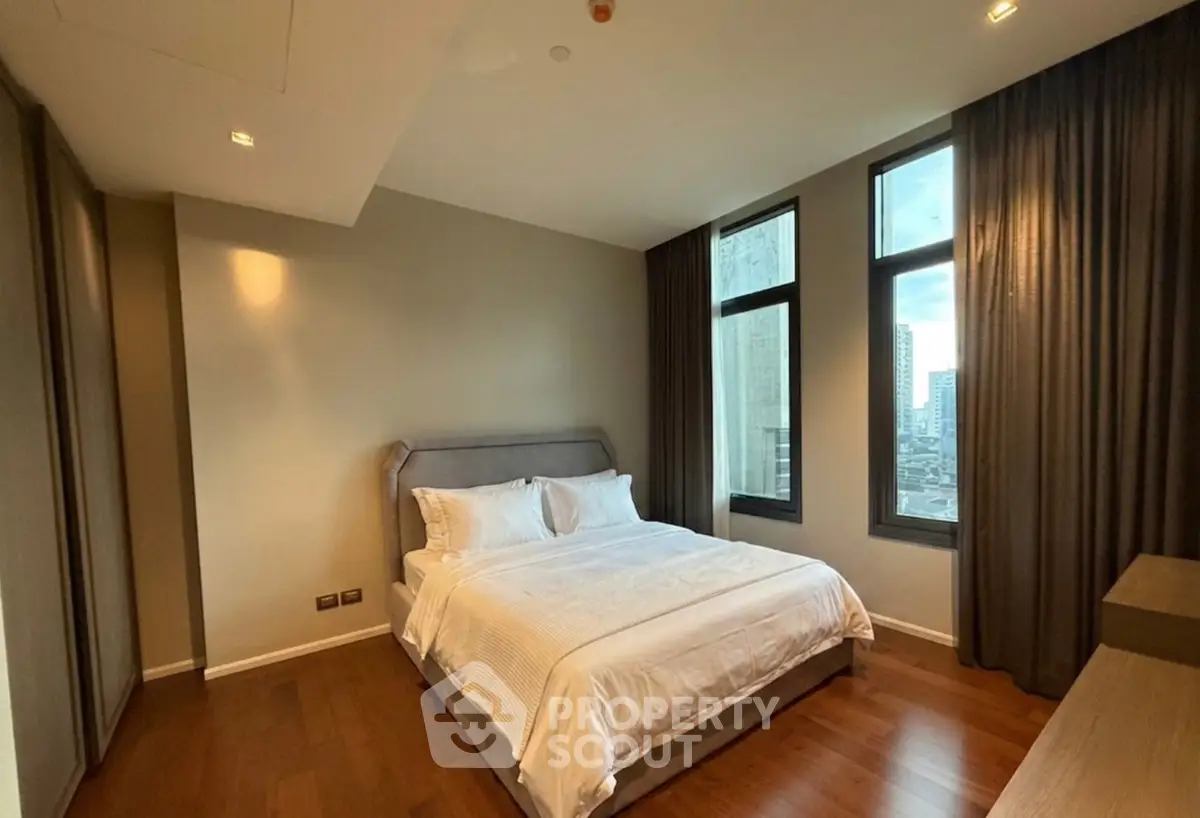 Spacious bedroom with large windows and elegant decor in modern apartment