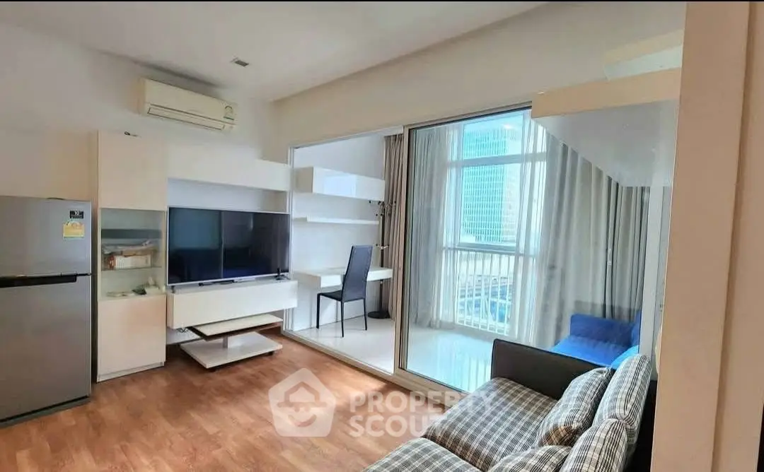 Modern living room with balcony view and sleek furniture in a high-rise apartment.