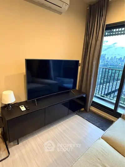 Modern living room with city view, featuring sleek TV setup and cozy ambiance.